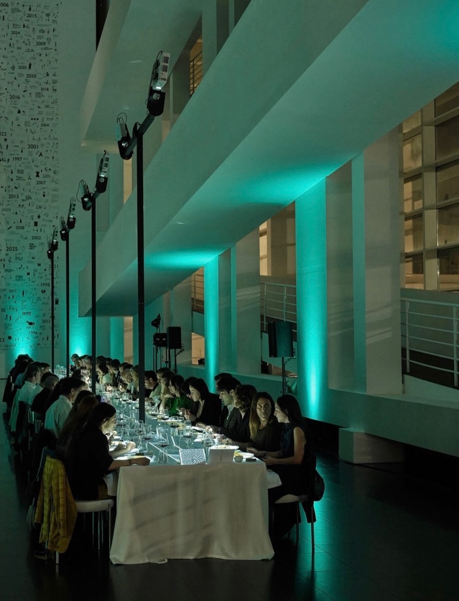 Long dinner table lit in turquoise inside MACBA