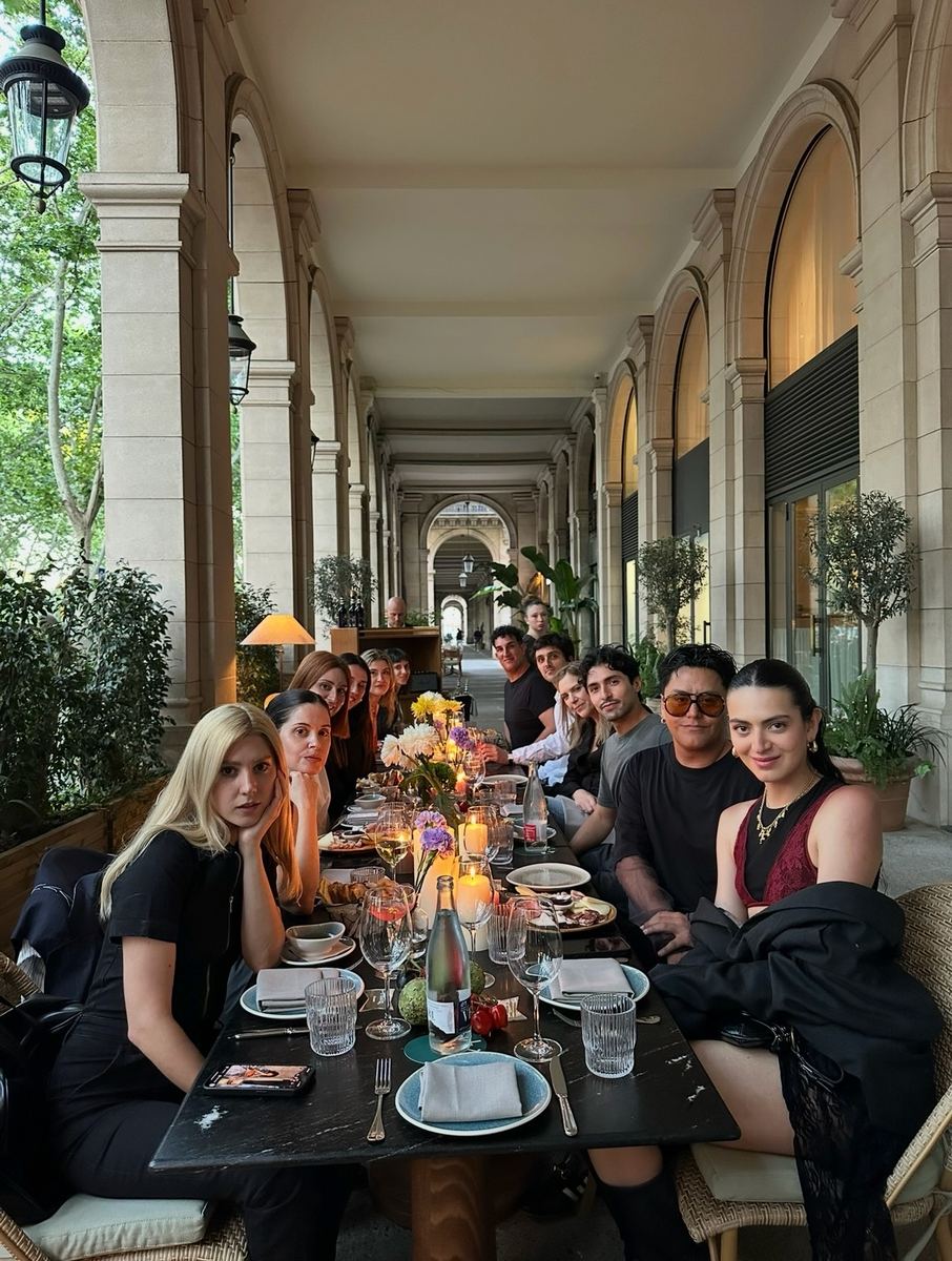 Guests at a long table under the arches of Hotel Borneta